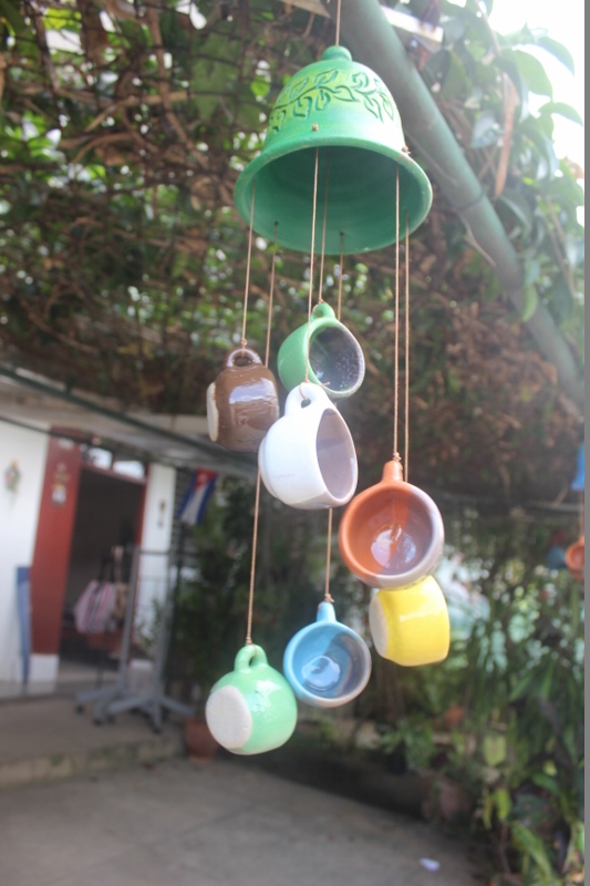 Wind chime made out of a bell and several colorful ceramic mugs